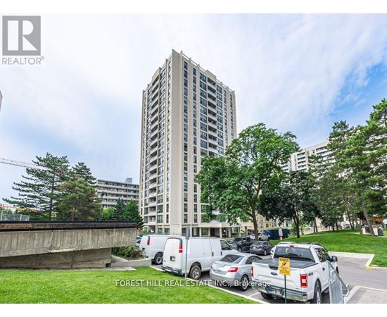 A tall building with a parking lot in front of it.