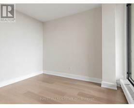 A room with a light brown floor and white walls.