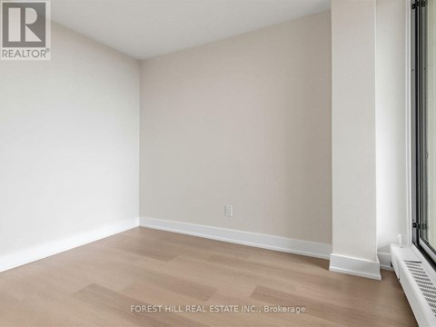 A room with a light brown floor and white walls.