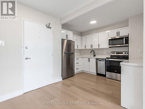 A kitchen with white cabinets and stainless steel appliances.