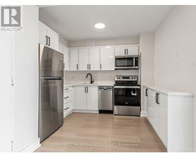 A kitchen with white cabinets and stainless steel appliances.