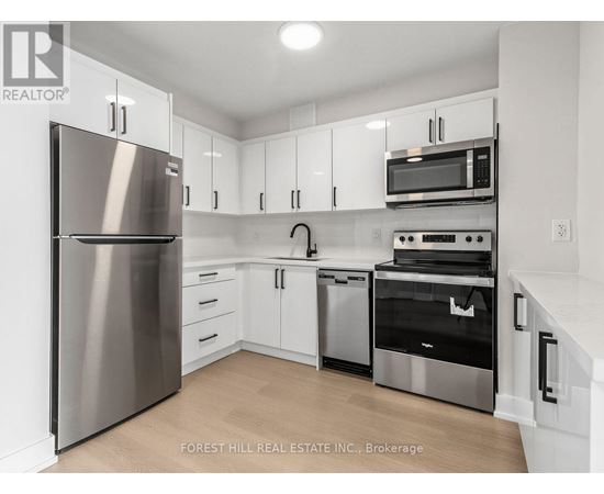 A kitchen with a stainless steel refrigerator, microwave, oven, and dishwasher.