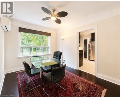 A room with a table and chairs and a ceiling fan.