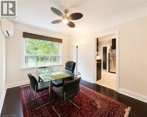 A room with a table and chairs and a ceiling fan.