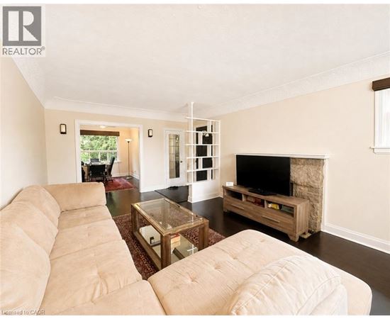 A living room with a beige couch and a television.