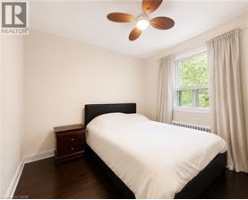 A bedroom with a bed, nightstand, and window.