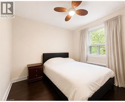 A bedroom with a bed, nightstand, and window.