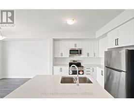 A kitchen with white cabinets and stainless steel appliances.