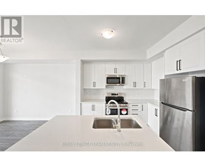 A kitchen with white cabinets and stainless steel appliances.