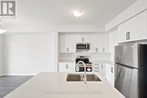 A kitchen with white cabinets and stainless steel appliances.