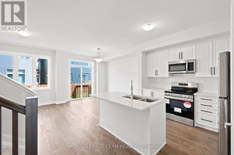 A white kitchen with a stove top oven and microwave.