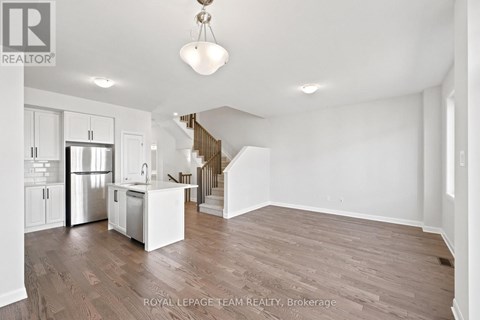 A spacious, empty room with wooden floors and white walls.