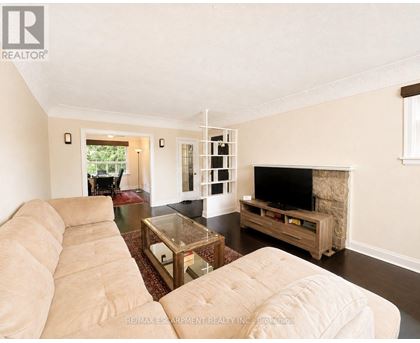 A living room with a beige couch and a glass coffee table.