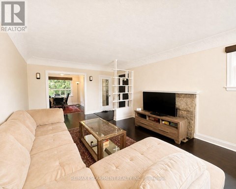 A living room with a beige couch and a glass coffee table.