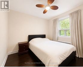 A bedroom with a bed, nightstand, and window.