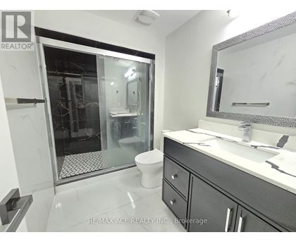 A bathroom with a toilet, sink, and shower.