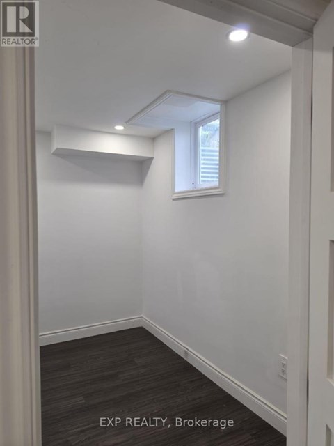 A room with a window and a wooden floor.