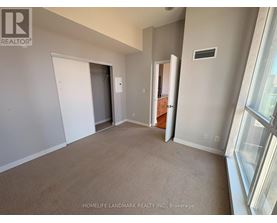 A room with a carpeted floor and a window on the right side.