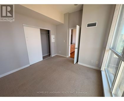 A room with a carpeted floor and a window on the right side.