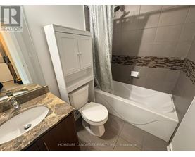 A bathroom with a toilet, sink, and bathtub.