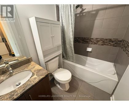 A bathroom with a toilet, sink, and bathtub.