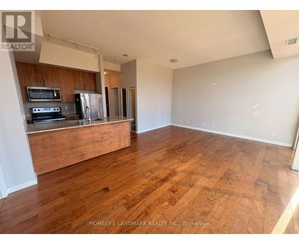 A kitchen with wooden floors and a stove top oven.