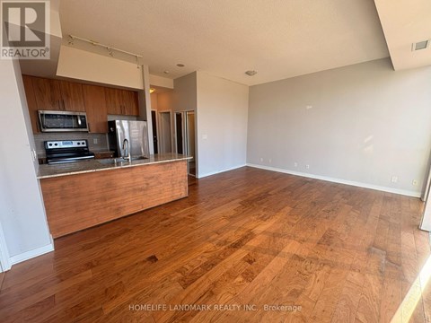A kitchen with wooden floors and a stove top oven.