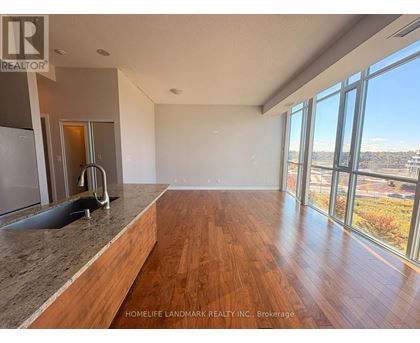 A spacious room with wooden floors and large windows overlooking a cityscape.