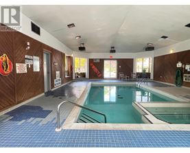 A large indoor swimming pool with a blue tiled floor.