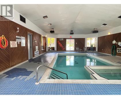 A large indoor swimming pool with a blue tiled floor.