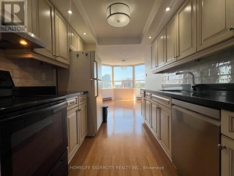 A kitchen with wooden cabinets and black countertops.