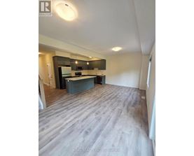 A spacious kitchen with a modern design featuring a dark countertop and a light-colored floor.