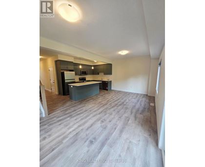 A spacious kitchen with a modern design featuring a dark countertop and a light-colored floor.