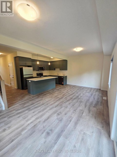 A spacious kitchen with a modern design featuring a dark countertop and a light-colored floor.