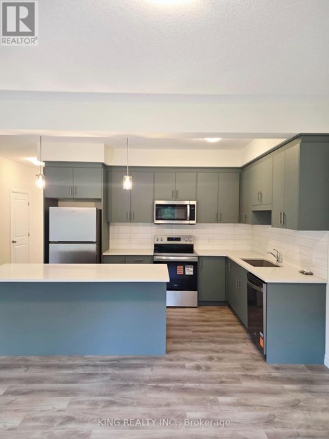 A modern kitchen with a stove top oven and a refrigerator.