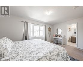 A bedroom with a large bed and a desk with a mirror.