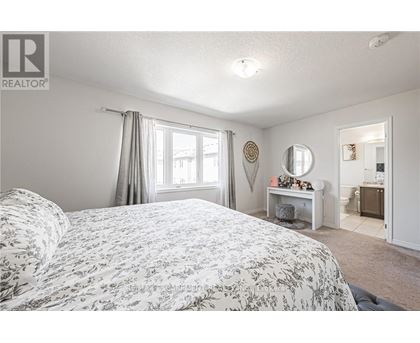 A bedroom with a large bed and a desk with a mirror.