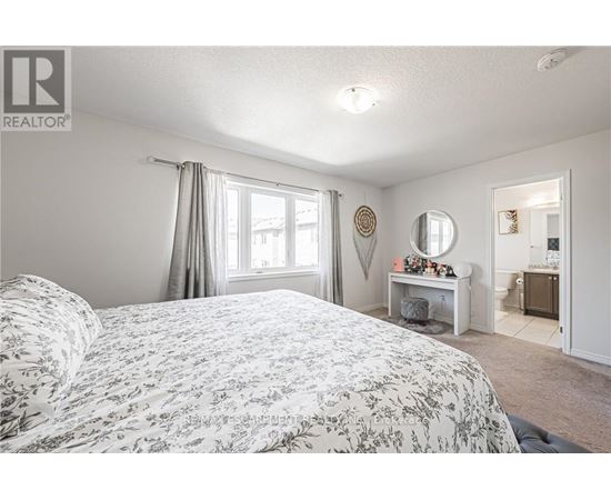 A bedroom with a large bed and a desk with a mirror.