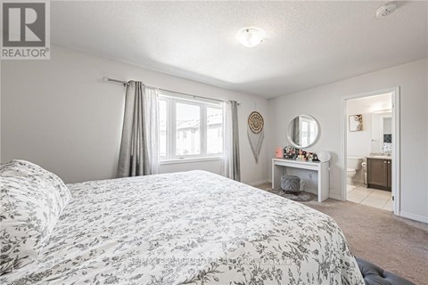 A bedroom with a large bed and a desk with a mirror.