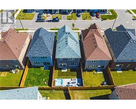 A bird's eye view of a row of houses with a swimming pool in the foreground.