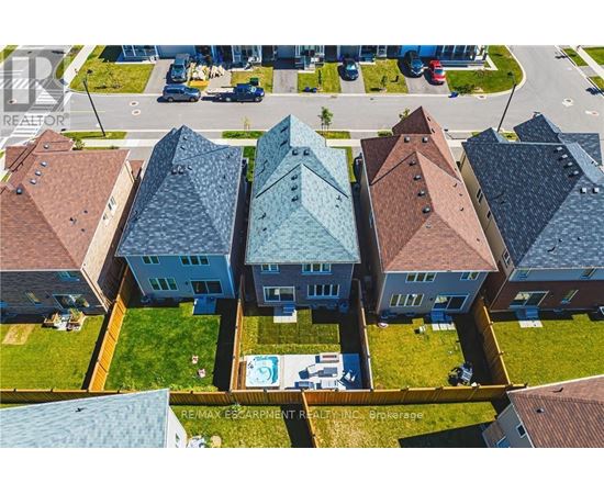 A bird's eye view of a row of houses with a swimming pool in the foreground.
