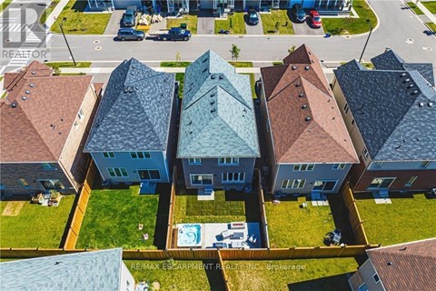 A bird's eye view of a row of houses with a swimming pool in the foreground.