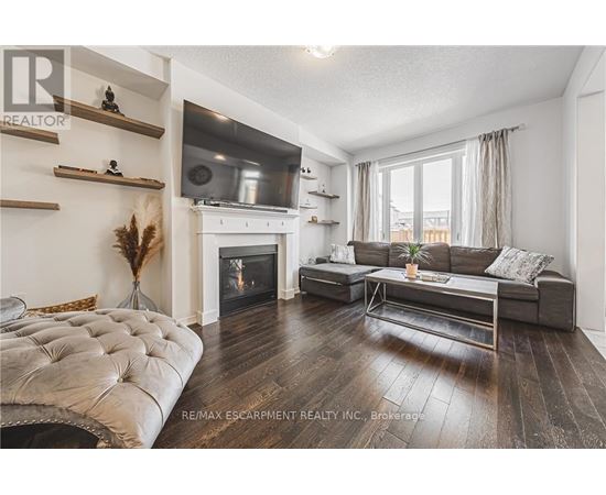 A living room with a fireplace and a grey sofa.