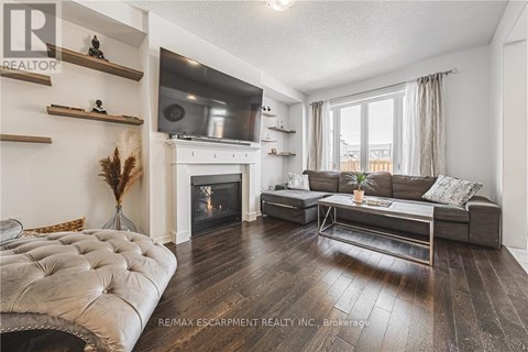 A living room with a fireplace and a grey sofa.