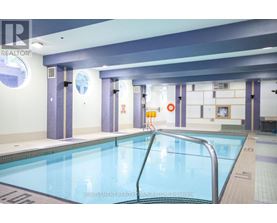 A large indoor swimming pool with a ladder on the right side.