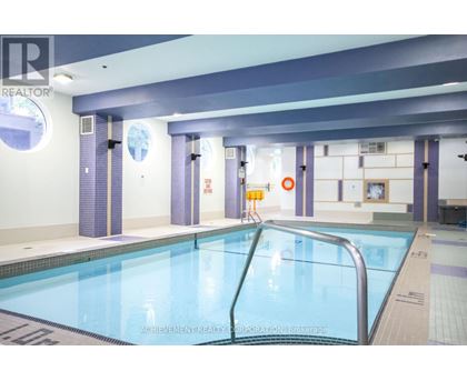 A large indoor swimming pool with a ladder on the right side.