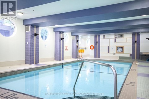 A large indoor swimming pool with a ladder on the right side.