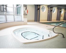 A hot tub in a room with a sign that says "Emergency Telephone".