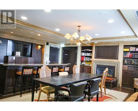 A dining room with a fireplace and a bookshelf.