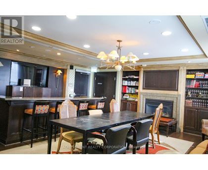 A dining room with a fireplace and a bookshelf.